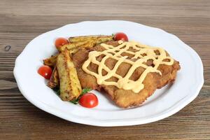 Crispy Chicken paneer and cheese with cherry tomato served in dish isolated on table side view of arabic food photo