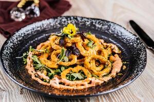 Deep Fried Crispy Calamari Fritti squid rings served in dish isolated on table side view of arabic appetizer food photo