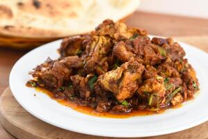 Chicken krahi korma masala with tandoori roti bread served in dish isolated on wooden table top view middle eastern breakfast food photo