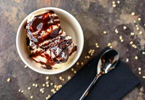 Bounty ice cream, white chocolate chip, and spoon served in cup isolated on dark background closeup top view of cafe baked dessert food photo