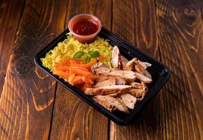 Grill Chicken Slice with Yellow Rice and sauce served in dish isolated on wooden table side view of arabic food photo