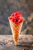 fresa helado con hielo crema, chocolate servido en cono aislado en oscuro antecedentes de cerca lado ver de café horneado postre comida foto