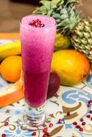 Fresh pomegranate juice served in glass isolated on table side view of arabic drink photo