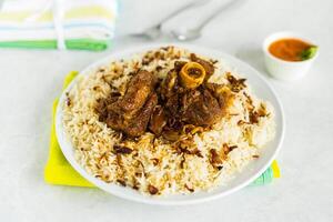 Meat mandi biryani rice served in dish isolated on table top view of arabic food photo