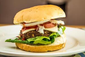 Meat Burger with tomato and cheese slice served in dish isolated on table top view of arabic fastfood photo