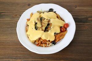 Grilled chicken pasta and cheese with black olive, cherry tomato, chili sauce and coriander served in dish isolated on table top view of arabic food photo