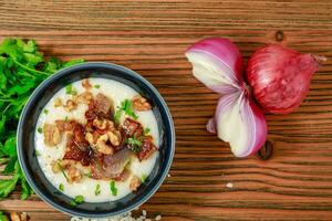 Egyptian Kishk keshj almaz with wlanuts, Coriander, and onion served in pot isolated on table top view of arabic food photo