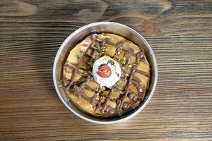 chocolate goulash served in dish isolated on wooden table top view of arabic dessert food photo