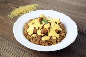 Crispy chicken and cheese noodles with bell pepper and coriander served in dish isolated on table side view of arabic food photo