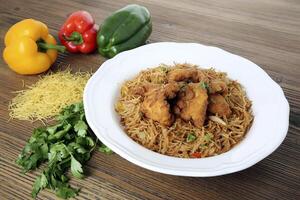 Crispy chicken noodles with bell pepper and coriander served in dish isolated on table side view of arabic food photo