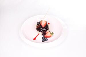 CALIFORNIAN BAKED CHEESE CAKE slice with strawberry, blueberry and caramel served in plate isolated on background side view of arab foodk photo