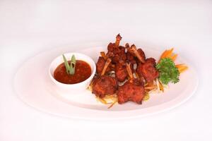 CHICKEN LOLLYPOP or chicken lollipops with chilli sauce served in dish isolated on background side view of arab food photo