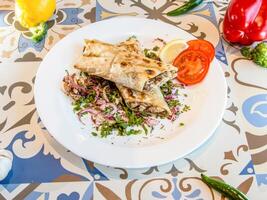 pollo musakán emparedado shawarma envolver lleno con tomate y cebolla servido en plato aislado en mesa parte superior ver de Arábica comida foto