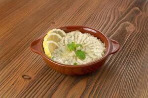 Baba ghanoush with lemon slice and mint served in dish isolated on wooden table side view of arabic food photo