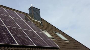 Solar panels producing clean energy on a roof of a residential house video