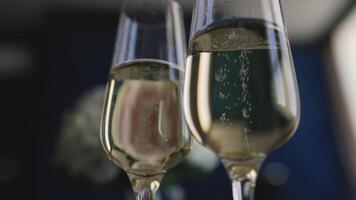 Close-up of two wedding glasses with champagne. Two glasses of champagne, close-up. Two glasses of champagne on a dark background. video