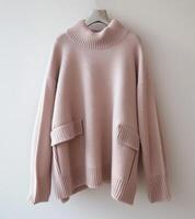 Pink Sweater Hanging on White Wall photo