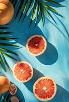 Grapefruits, Oranges, and Palm Leaves on Blue Surface photo