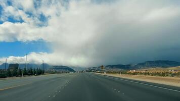 Desert Highway Approaching Storm, Desert highway leading towards stormy mountains. video