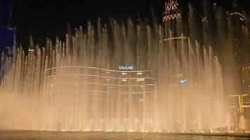 UAE, Dubai - United Arab Emirates 01 April 2024 Fountain Show in Front of a Skyscraper, Majestic fountain display with illuminated high-rise buildings as a backdrop at night. video