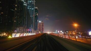 uae, dubai - förenad arab emirates 01 april 2024 dubai metro rida på natt, de dubai metro hastigheter genom de stad på natt, visa upp de urban landskap och vibrerande stad lampor. video