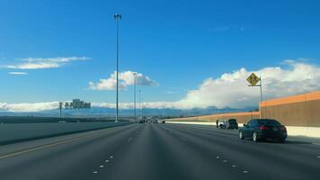 Highway View Towards Mountain Range, Open highway leading towards a distant mountain range under blue skies. video