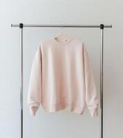 Pink Sweater Hanging on White Wall photo