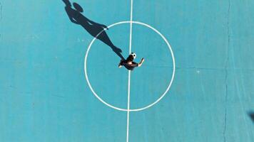 Soccer Player Plays Ball Trick in Blue Field Overhead View video