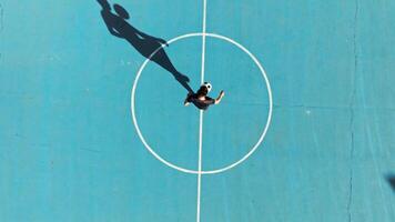 Soccer Player Plays Ball Trick in Blue Field Overhead View video