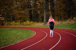 Woman running at stadium track photo