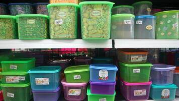 plates, spoons, plastic buckets, bowls, food storage containers and kitchen utensils on supermarket shelves, for sale photo