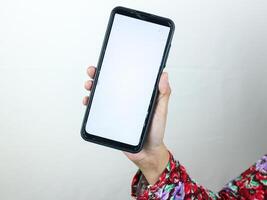 Hands of businesswoman holding smart phone with blank screen at loft office photo