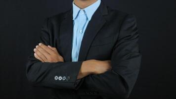 Businessman standing posture show arm crossed isolated on over black background photo