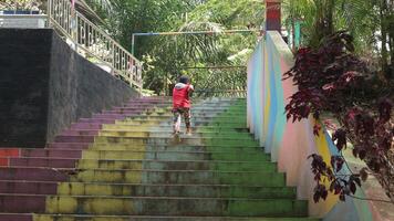 boys playing in the park, running up the colorful stairs photo