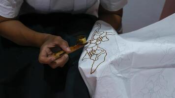 Woman hand making Indonesian batik with canting photo