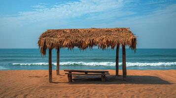 banco debajo Paja techo por el playa foto