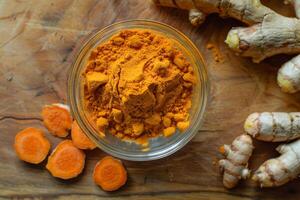 AI generated Vibrant orange turmeric powder in a clear glass bowl photo