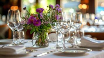 Table With Vase of Flowers and Wine Glasses photo