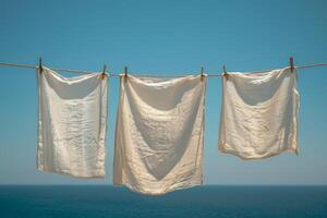 AI generated White clothes and linen hanging on a washing line against a clear blue sky photo