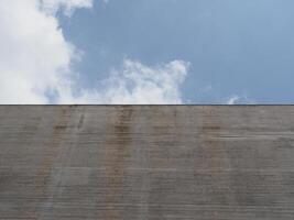 grey concrete wall over blue sky background photo