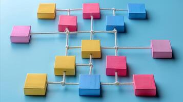 Colorful Wooden Blocks Connected by Strings on Blue Background photo