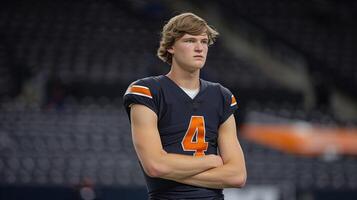 Pensive Football Player Standing on Field at Dusk photo