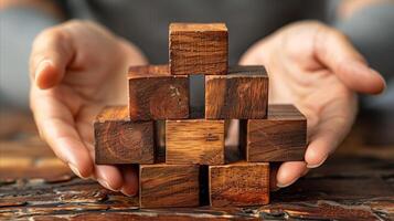 Hands Constructing a Wooden Block Puzzle on a Table photo