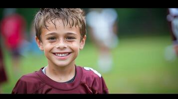 sonriente joven chico en fútbol americano engranaje durante práctica foto