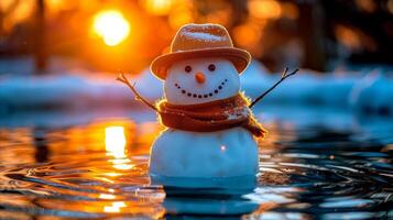 Tranquil image of a snowman standing in water as the sun sets in the distance. photo