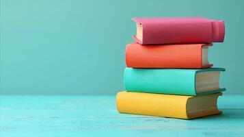 Colorful Stack of Books Against a Teal Background photo