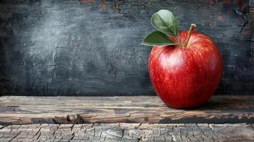 Red Apple on Rustic Wooden Table Against Dark Background photo