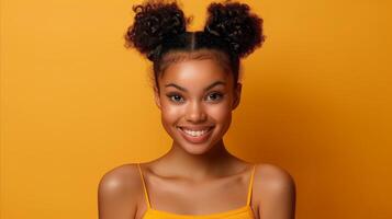 Radiant Young Woman With Double Buns Smiling Against Yellow Background photo