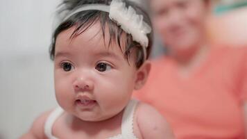 A woman holds a baby whose tongue is sticking out. video