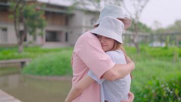 avvicinamento di un' coppia abbracciare ogni altro in piedi nel un' giardino. famiglia, le persone, amore e relazioni abbracciato con amore e cura. video